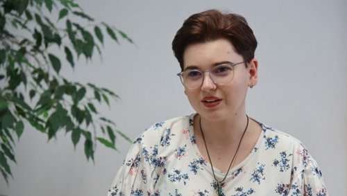 Foto: Birbaumer Christof Frau Katharina Prohászka ist während des Interviews vor einer Pflanze zu sehen. Sie trägt eine gemusterte Bluse.