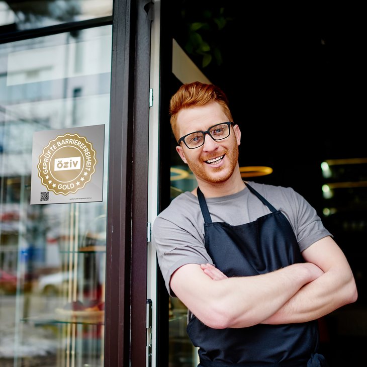 Ein Mann steht vor einem Café mit dem ÖZIV Gütesiegel