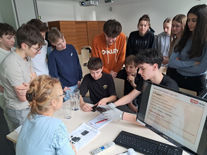 Eine Gruppe von Schüler:innen testet ein Tremor-Simulationsgerät.