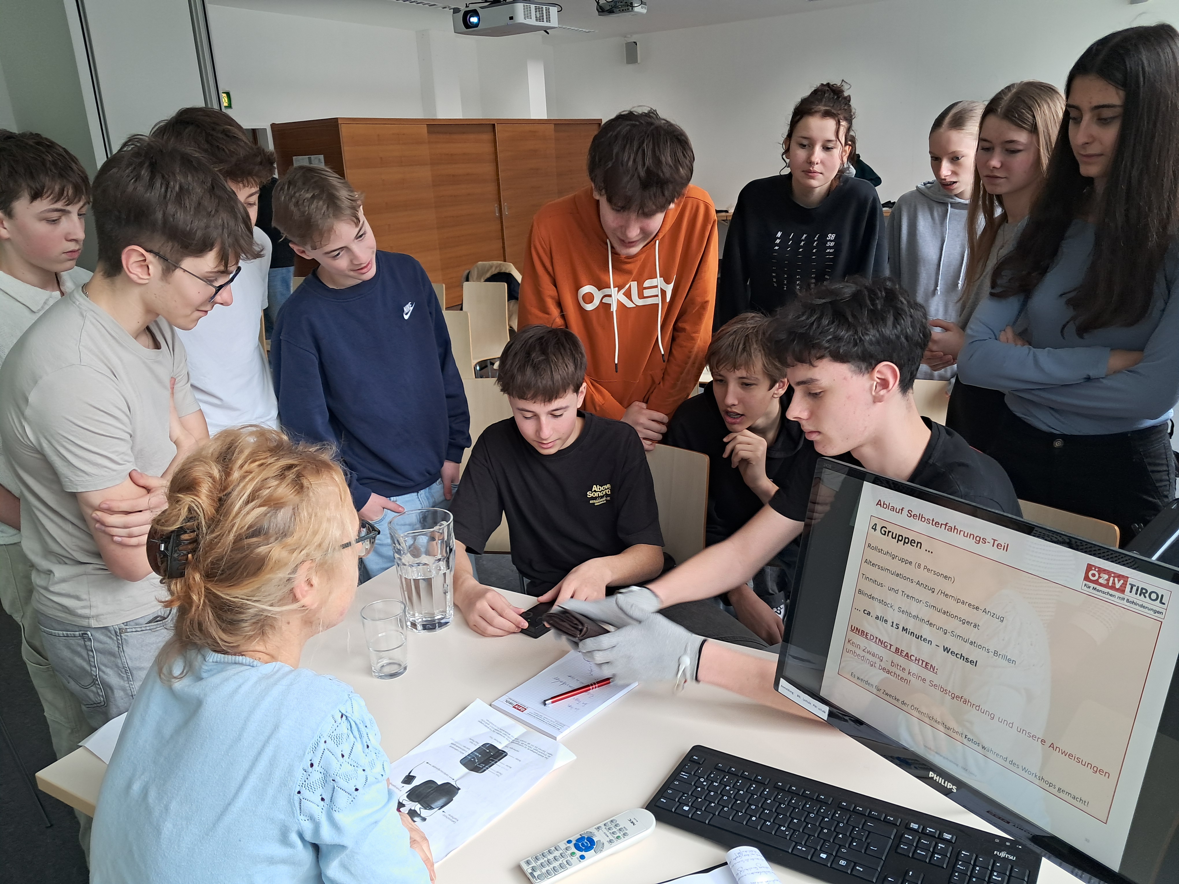 Eine Gruppe von Schüler:innen testet ein Tremor-Simulationsgerät.